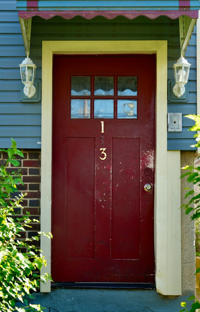 Charming red door with the number 13 on a cozy New Jersey house.